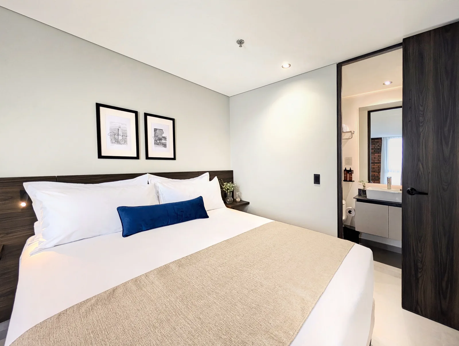 Quarto com cama king em uma suíte do Laureles Selection Suites